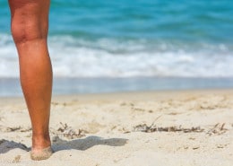 Schöne Beine am Strand von Sardinien.